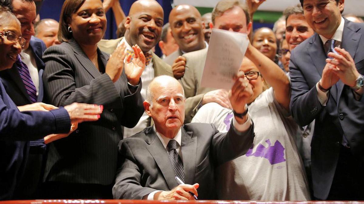 California Governor Jerry Brown signs a minimum wage bill at the Ronald Reagan State Building on Monday, April 4 in Los Angeles.
