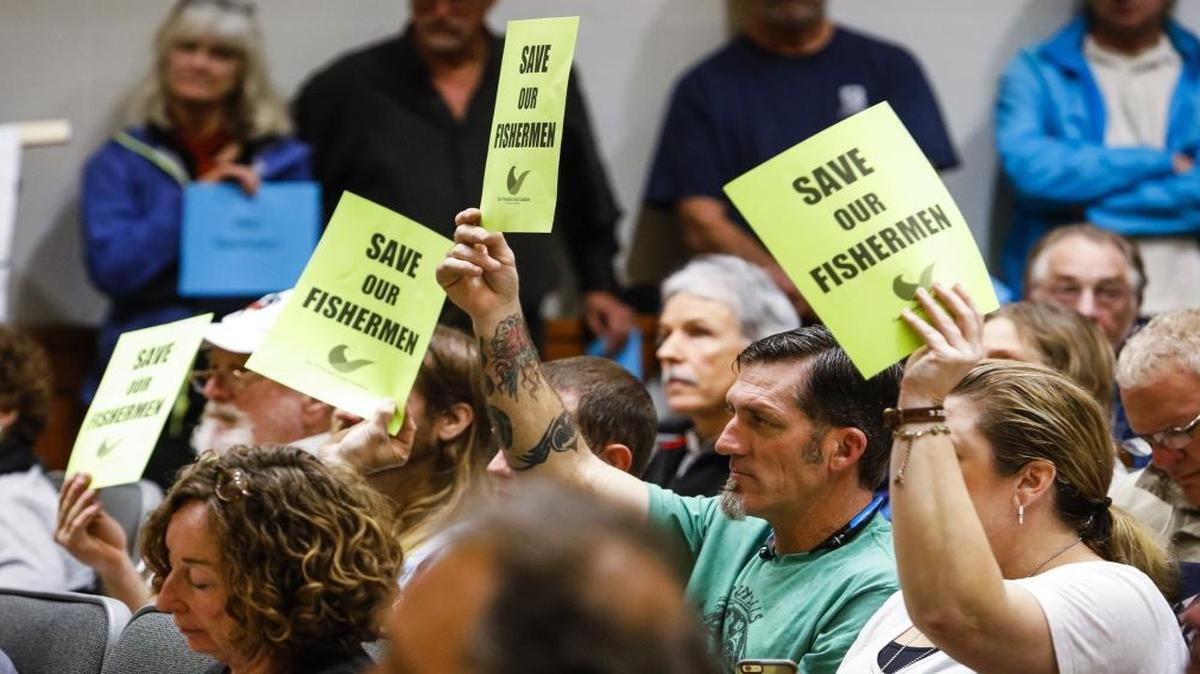 Opponents of the Chumash Heritage National Marine Sanctuary hold signs during the San Luis Obispo County Board of Supervisors meeting on Feb. 7, 2017.
