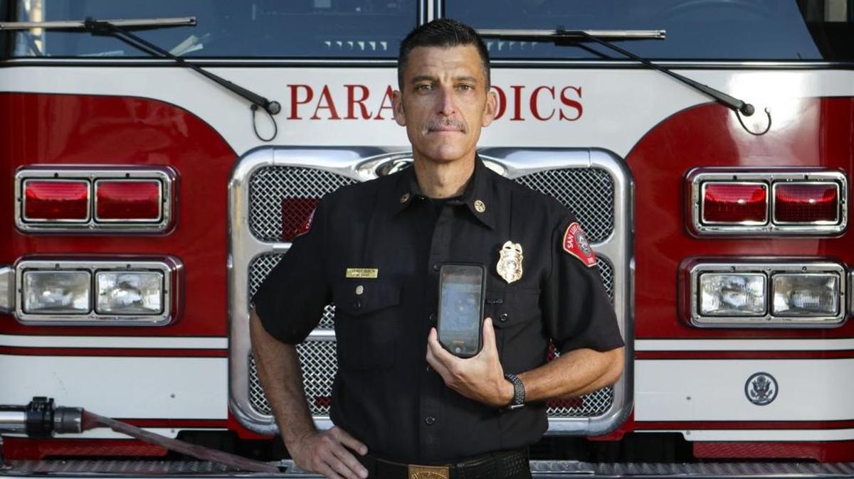 Former San Luis Obispo Fire Chief Garret Olson shows off the PulsePoint app that alerts volunteers trained in CPR when someone nearby has suffered a cardiac arrest. The city announced this week that people can pick up free File of Life cards.