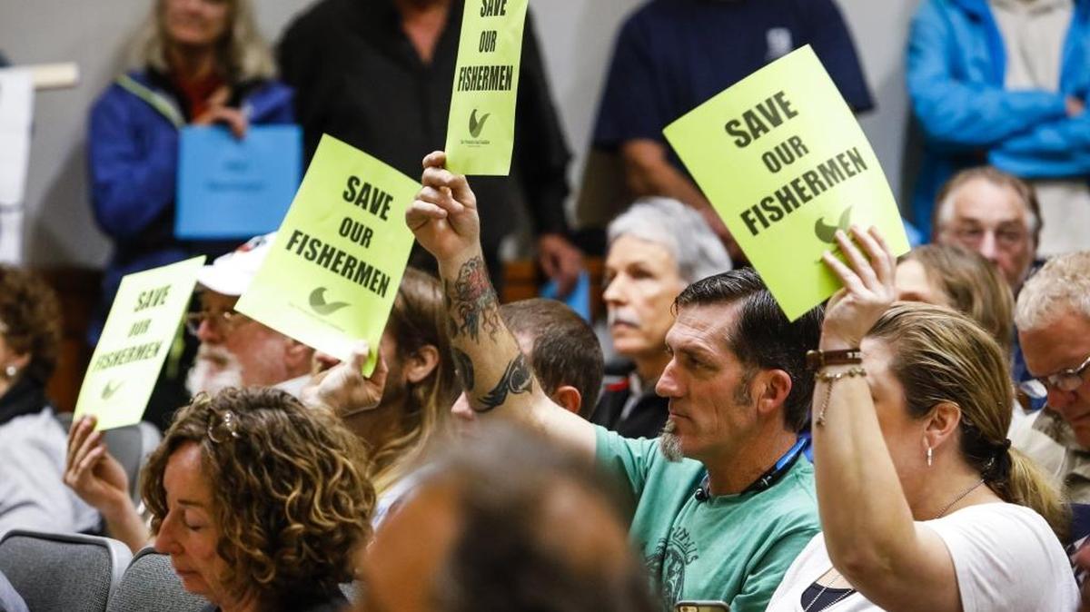 Opponents of the Chumash Heritage National Marine Sanctuary hold signs during the San Luis Obispo County Board of Supervisors meeting Feb. 7, 2017.