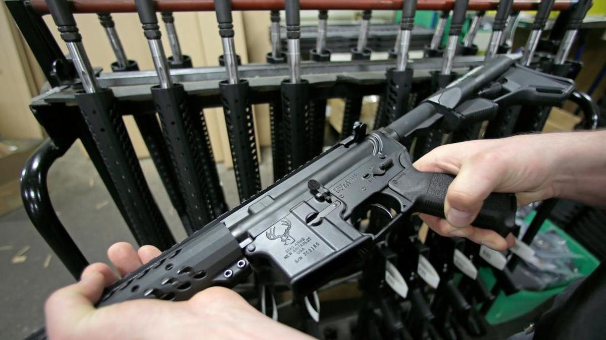 FILE - In this April 10, 2013, file photo, a man holds a newly-assembled AR-15 rifle in New Britain, Conn. A gun shop in McHenry, Ill., is raffling an AR-15 rifle to benefit victims of the June 12, 2016, nightclub shooting in Orlando, Fla. The semi-automatic weapon is similar to the one gunman Omar Mateen used in that shooting.