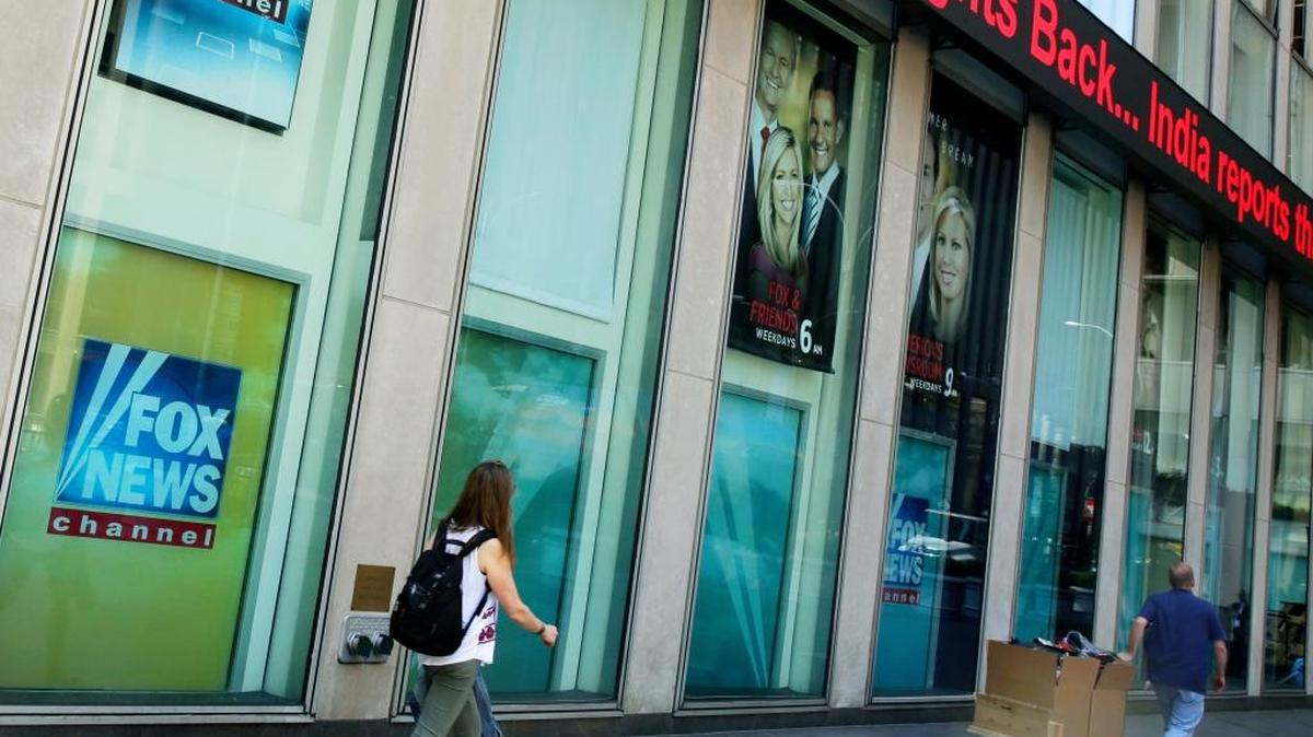 People pass the News Corporation headquarters building and Fox News studios in New York, Tuesday, Aug. 1, 2017.