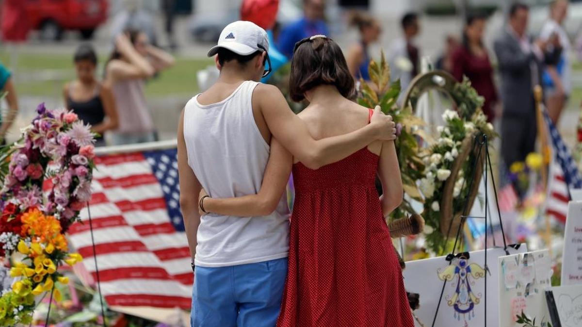 A couple spend a quiet moment at a makeshift memorial honoring the victims of the Pulse nightclub mass shooting Monday in Orlando, Florida.