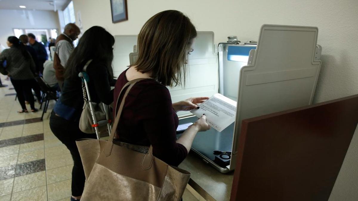 Kaitlin Harr looks over her ballot envelope before sealing it and depositing it in the ballot box at the Sacramento County Registrar of Voters office in Sacramento on Nov. 7, 2016.