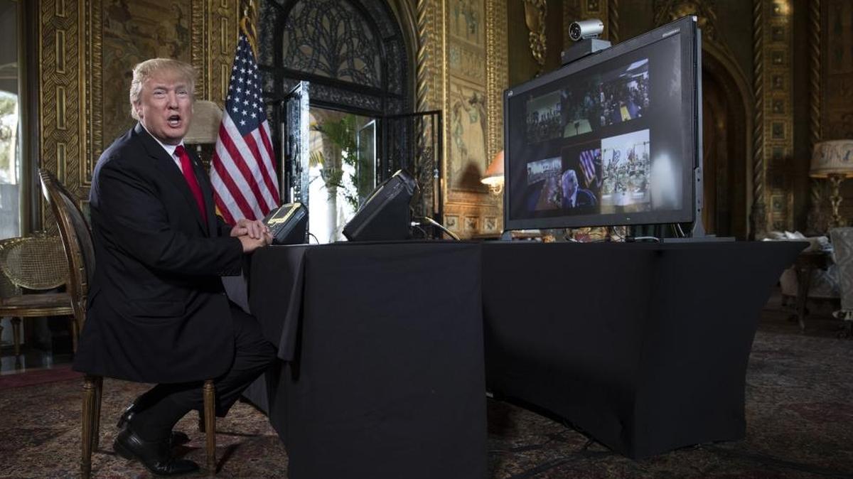 President Donald Trump turns to talk to the gathered media during a Christmas Eve video teleconference with members of the mIlitary at his Mar-a-Lago estate in Palm Beach, Fla., Sunday, Dec. 24, 2017.