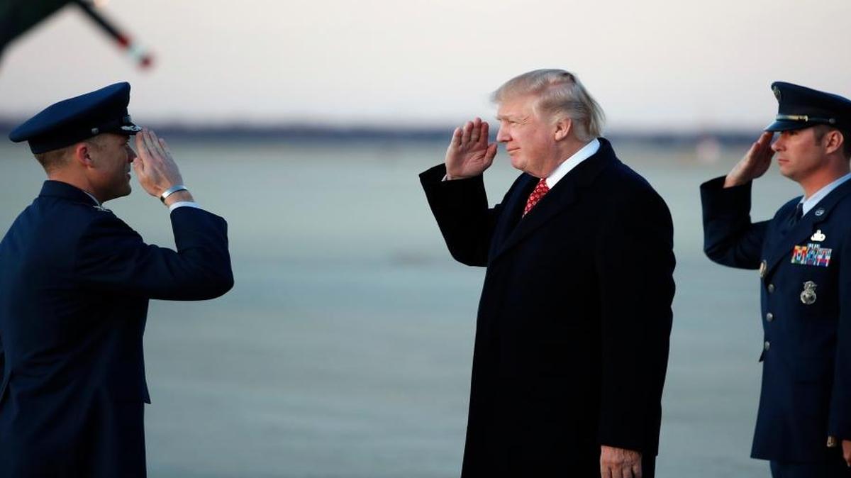 President Donald Trump salutes as he stands on the tarmac after disembarking Air Force One as he arrives Sunday, March 5, 2017, at Andrews Air Force Base, Md. Trump is returning from Mar-a-Largo, Fla.