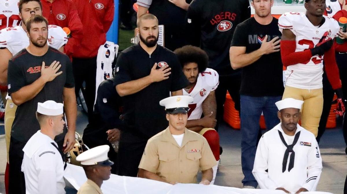 San Francisco 49ers quarterback Colin Kaepernick, middle, sits during the national anthem before an NFL preseason football game against the San Diego Chargers on Thursday, Sept. 1, in San Diego.