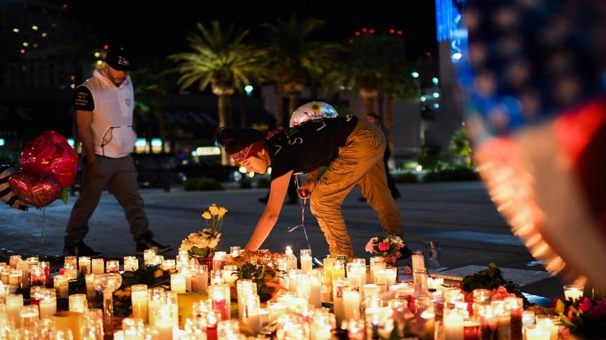 Priscilla Olivas lights a candle at a street vigil along the Las Vegas Strip on Monday.