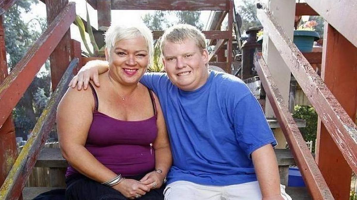 Tyler Jarvis, who has Prader-Willi syndrome, sits with his mom, Michelle Christian, in Pismo Beach.