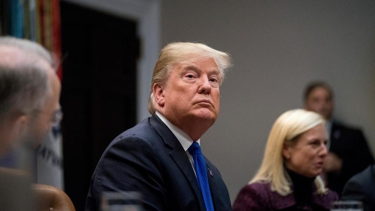 President Donald Trump, center, accompanied by Secretary of Homeland Security Kirstjen Nielsen, right, listens during a meeting on immigration in the Roosevelt Room at the White House, Thursday, Jan. 4, 2018, in Washington.
