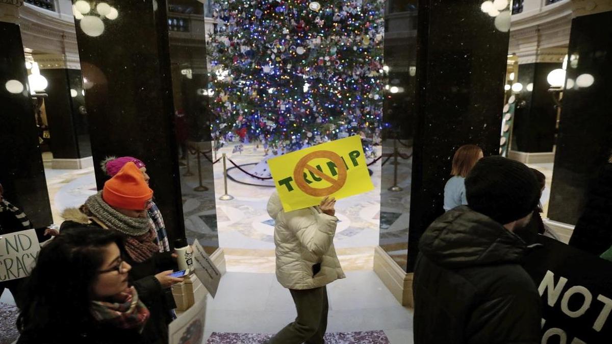 Protesters march around the state Capitol Rotunda an hour before Republican Electoral College voters gather to cast votes for President-elect Donald Trump and Vice President-elect Mike Pence in Madison, Wis., Monday, Dec. 19, 2016.