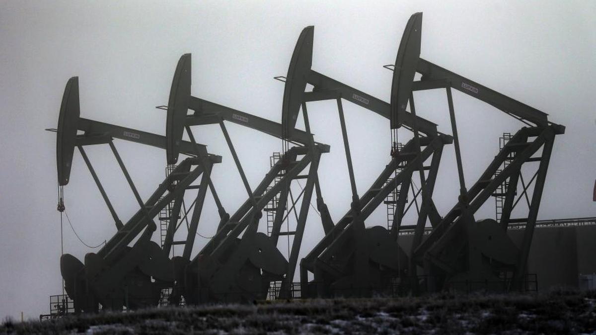 In this Dec. 19, 2014, file photo, oil pump jacks work in unison in Williston, N.D.