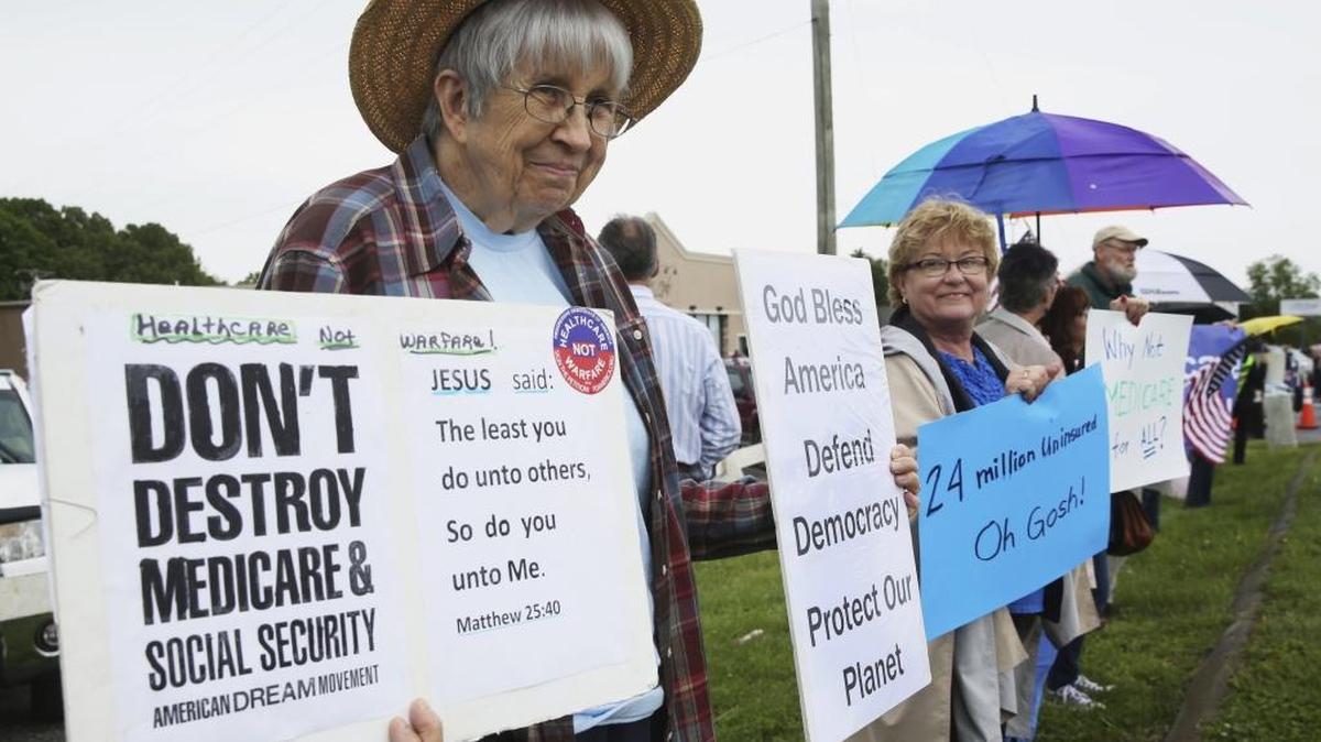 Sally Park, 81, of Charlottesville and Alice Prather, 66, of Franklin County, protested along the side of Hendricks Store Road in Moneta, Va., Tuesday, May 9, 2017, before the arrival of U.S. Rep. Tom Garrett, R-Buckingham.