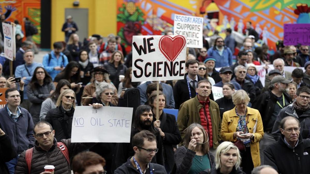 People hold signs as they listen to a group of scientists speak during a rally in conjunction with the American Geophysical Union’s fall meeting Tuesday, Dec. 13, 2016, in San Francisco. The rally was to call attention to what scientist believe is unwarranted attacks by the incoming Trump administration against scientists advocating for the issue of climate change and its impact.
