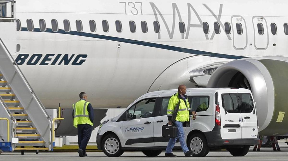 In this March 14, 2019, file photo, workers walk next to a Boeing 737 MAX 8 airplane parked at Boeing Field, in Seattle. A published report says pilots of an Ethiopian airliner that crashed followed Boeing's emergency steps for dealing with a sudden nose-down turn but couldn't regain control.