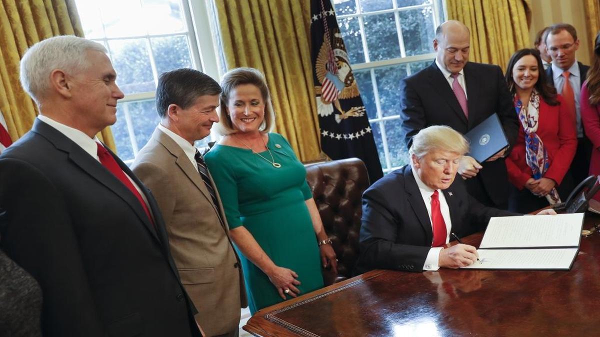 President Donald Trump signs an executive order in the Oval Office of the White House in Washington, Friday, Feb. 3, 2017.