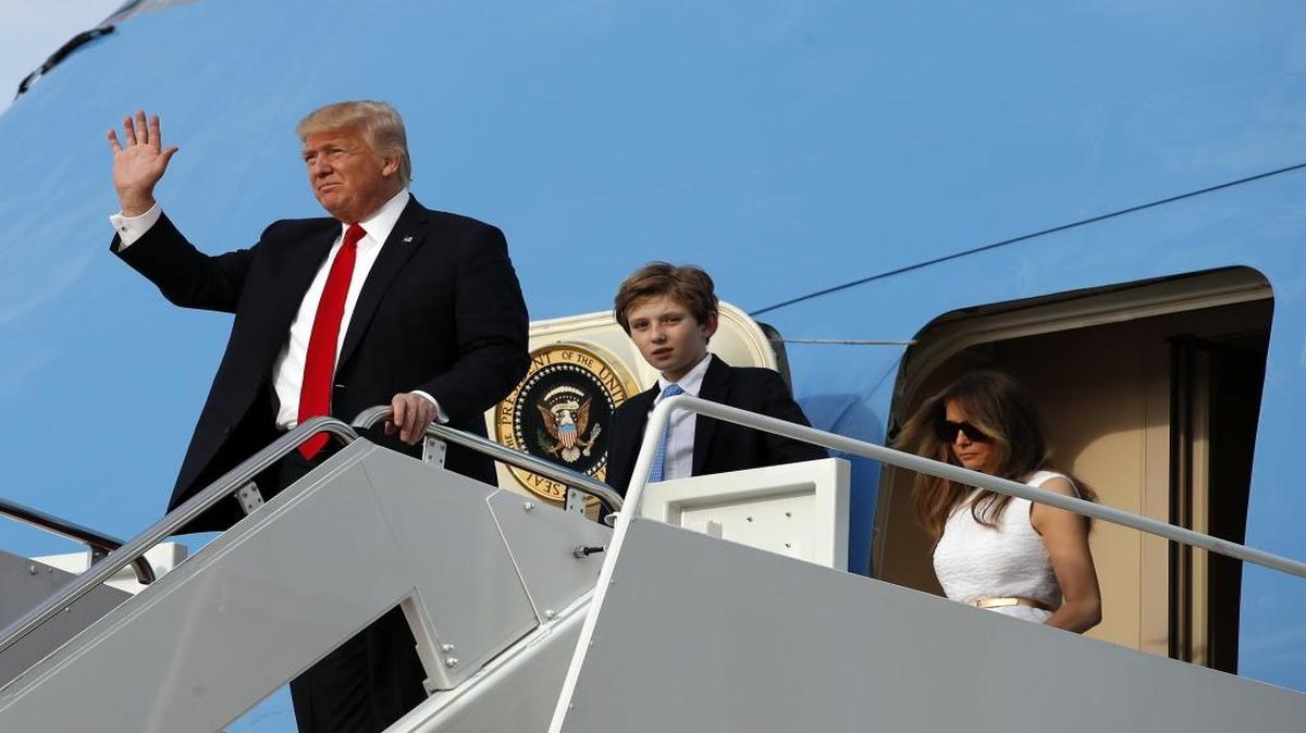President Donald Trump waves as first lady Melania Trump, right, and son Barron Trump, 11, step off Air Force One as they arrive Sunday, April 16, 2017, at Andrews Air Force Base, Md. Trump is returning from his Mar-a-Largo resort in Florida.