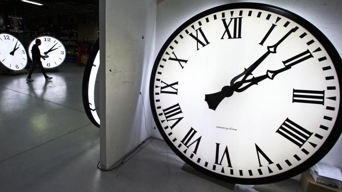 Tom Liberatore, a materials purchasing manager, walks past clocks being tested prior to shipping at the Electric Time Company in Medfield, Mass., on March 10, 2016. Most Americans lose an hour of sleep, but gain an hour of evening light during daylight saving time.