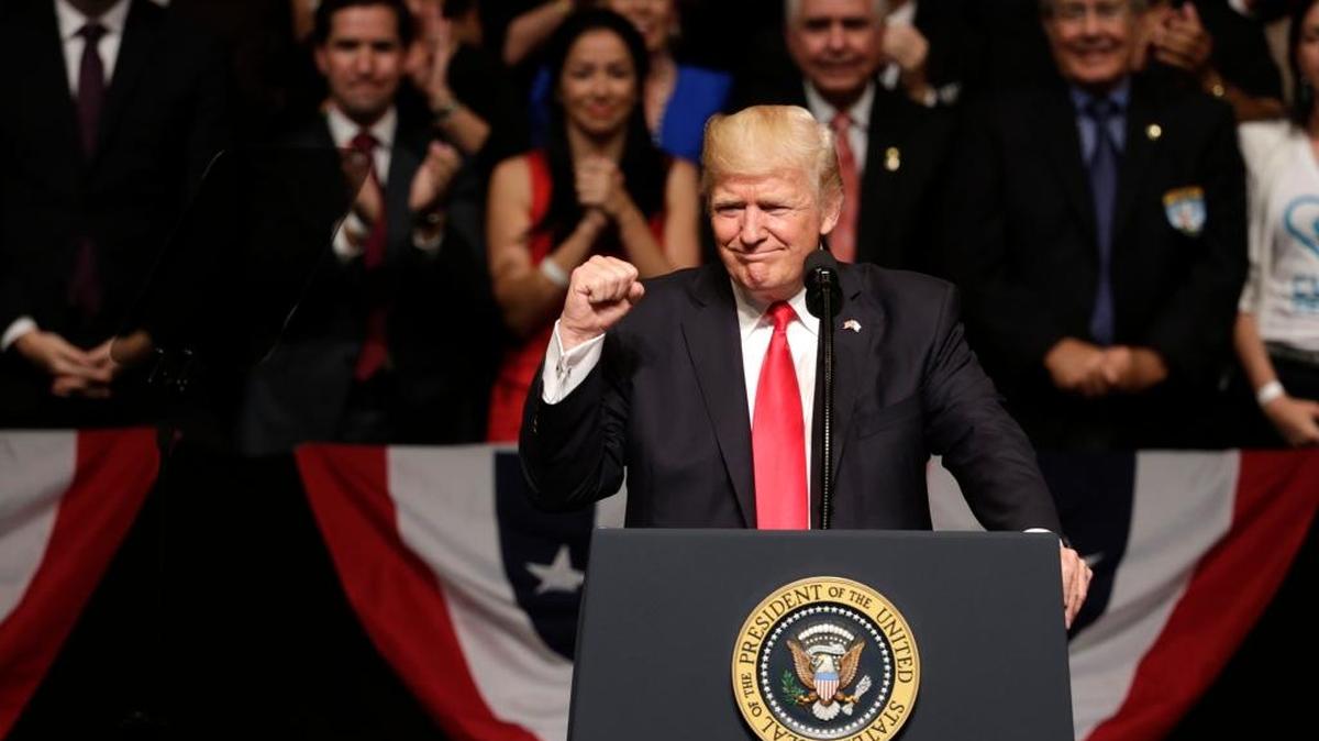 President Donald Trump clenches his fist as he announces a revised Cuba policy aimed at stopping the flow of U.S. cash to the country's military and security services while maintaining diplomatic relations, Friday, June 16, 2017, in Miami.