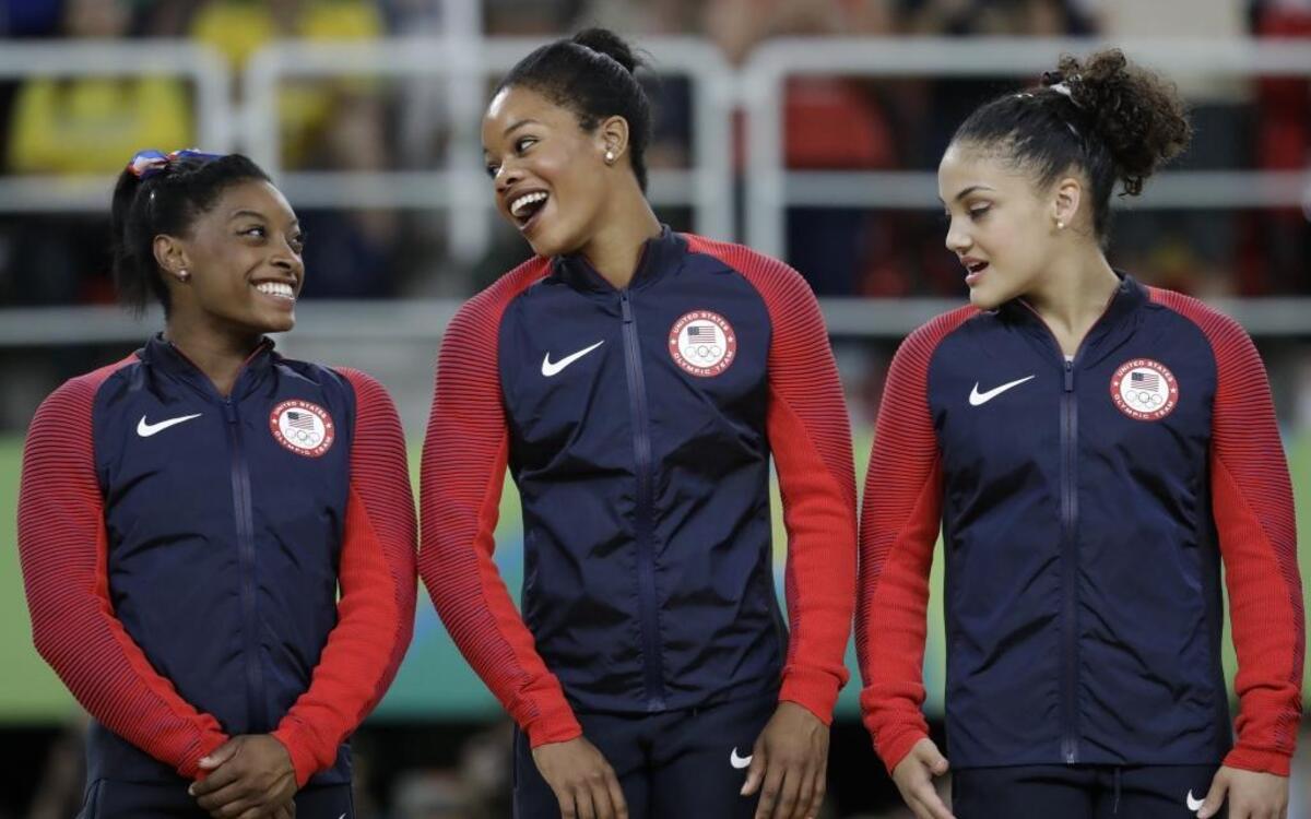 U.S. gymnasts and gold medalists, left to right, Simone Biles, Gabrielle Douglas and Lauren Hernandez celebrate on the podium during the medal ceremony for the artistic gymnastics women's team at the 2016 Summer Olympics in Rio de Janeiro, Brazil, Tuesday, Aug. 9, 2016.