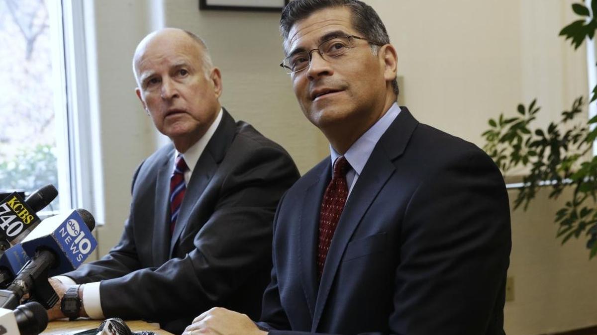 In this photo taken Monday, Dec. 5, 2016, Calif., Gov. Jerry Brown, left, and Rep. Xavier Becerra, D-Calif., Browns nominee for California Attorney General, listen to a reporter's questions during a news conference in Sacramento, Calif.