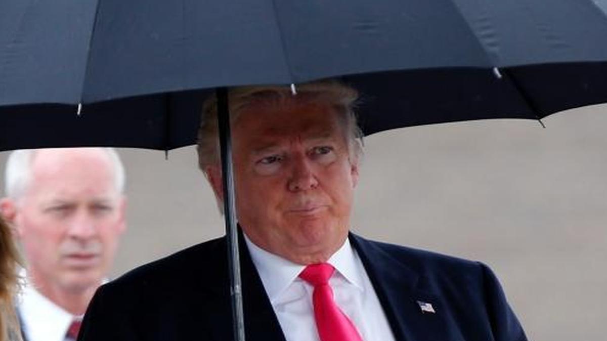 Donald Trump walks in the rain with Florida Attorney General Pam Bondi on Aug. 24, 2016.