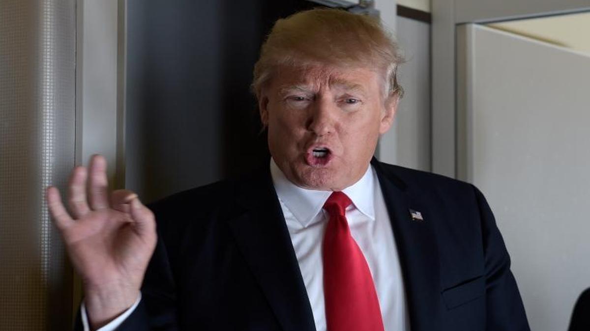 President Donald Trump speaks to reporters on Air Force One while traveling to Palm Beach International Airport in West Palm Beach, Fla., on Friday, Feb. 3, 2017.