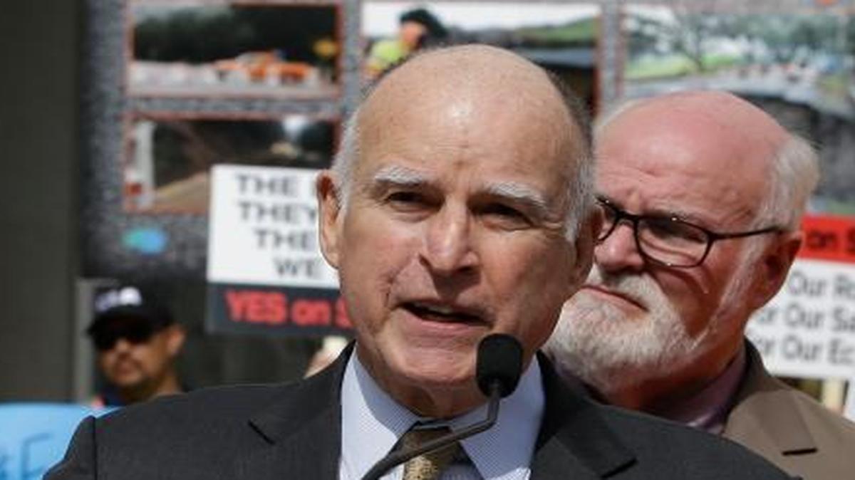 California Gov. Jerry Brown, center, urges lawmakers to approve a plan for a $5 billion-a-year tax and fee road repair measure during a rally April 5, 2017, in Sacramento.