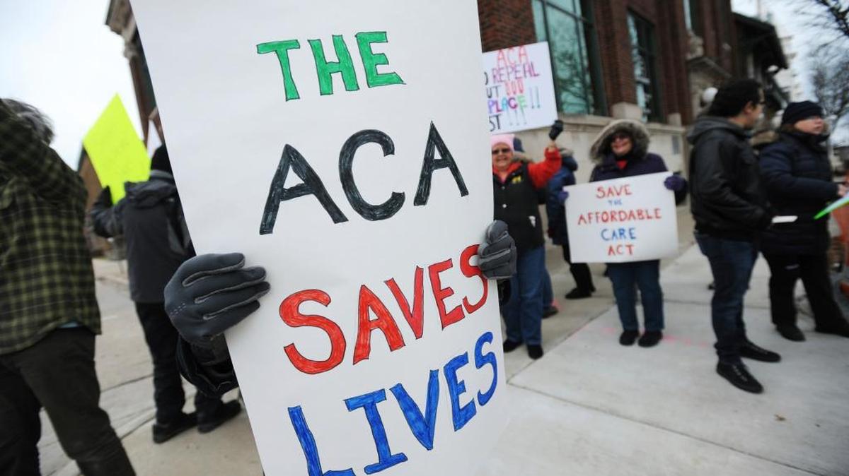 Dozens of Affordable Care Act supporters gather for a rally Saturday, Jan. 28, 2017, in downtown St. Joseph, Mich.