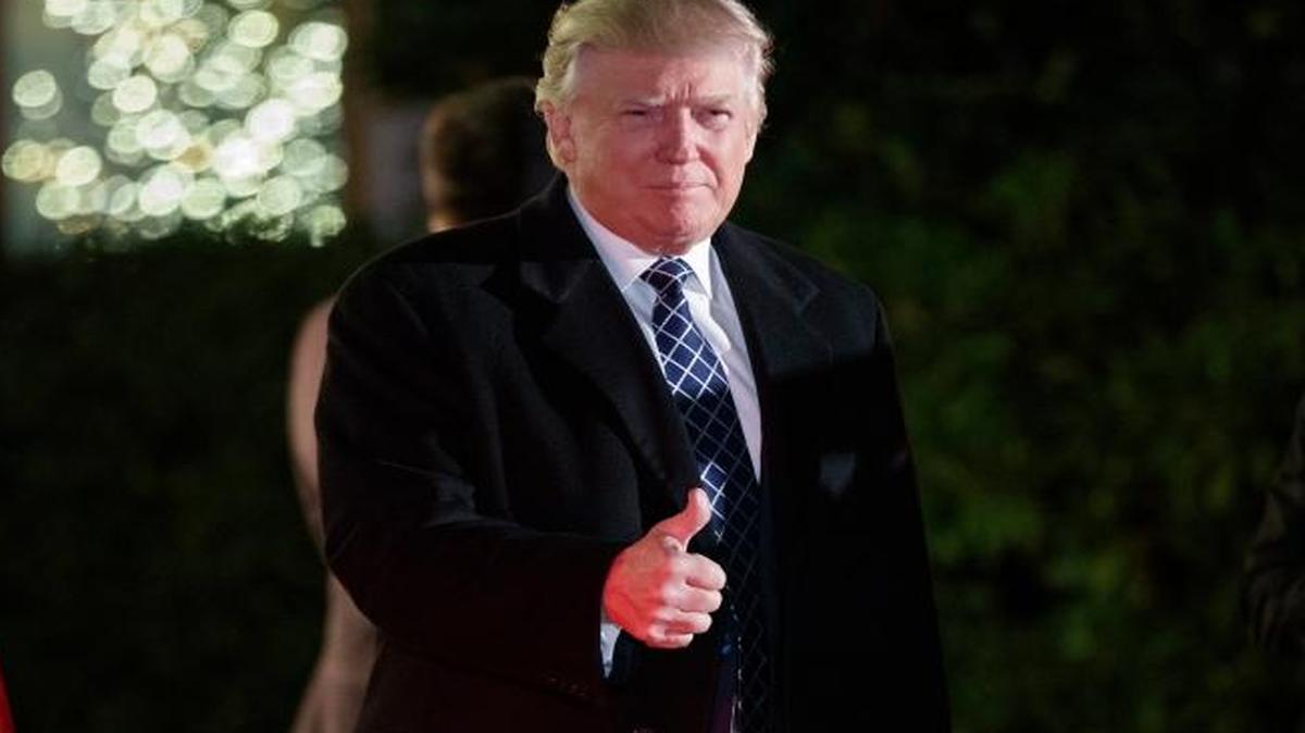 President-elect Donald Trump gestures toward reporters as he arrives for a party at the home of Robert Mercer, one of his biggest campaign donors, Saturday in Head of the Harbor, N.Y.