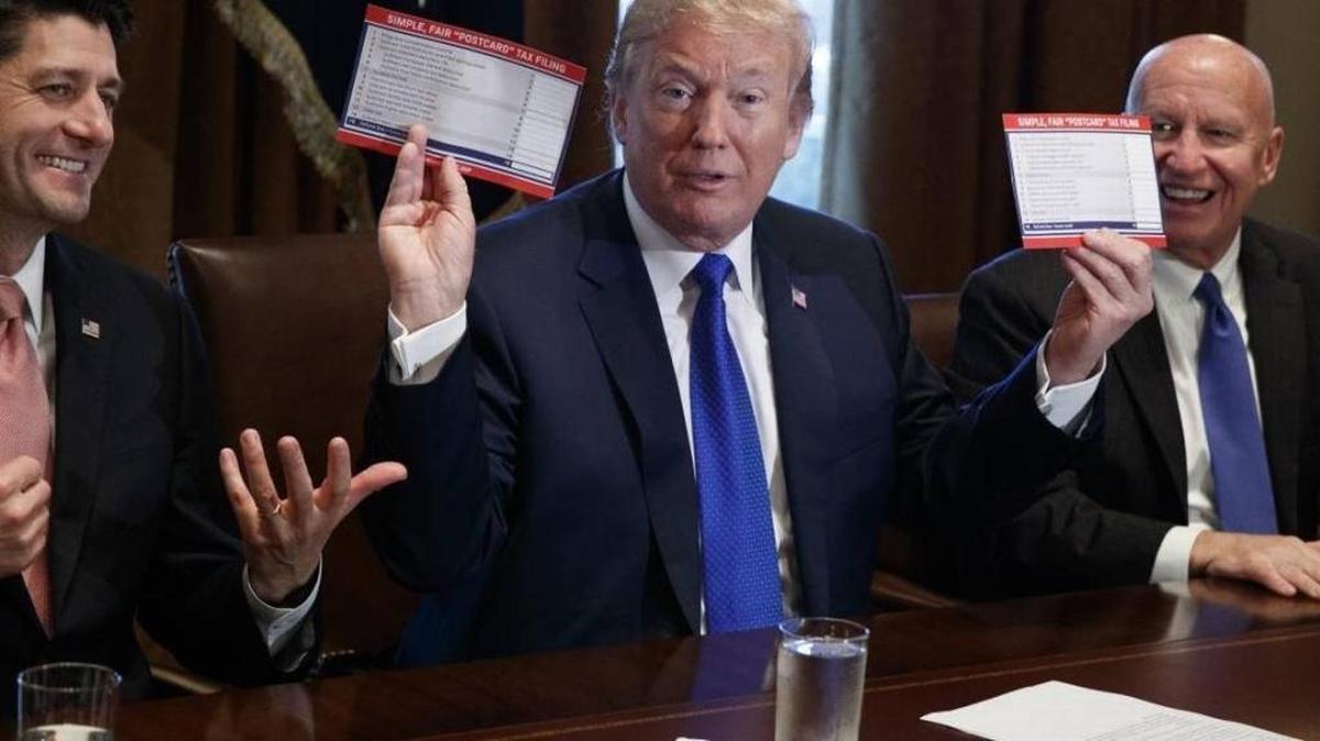 President Donald Trump holds an example of what a new tax form may look like during a meeting on tax policy with Republican lawmakers including House Speaker Paul Ryan of Wis., and Chairman of the House Ways and Means Committee Rep. Kevin Brady, R-Texas, right, in the Cabinet Room of the White House on Nov. 2