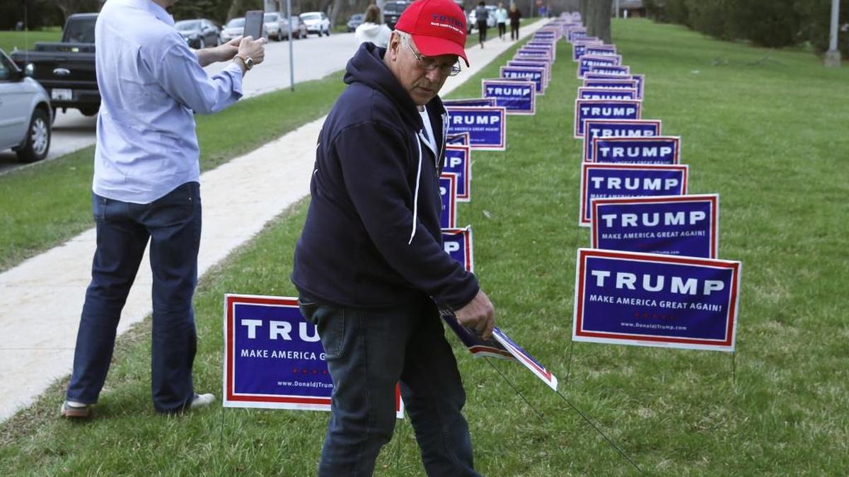 Volunteer Elam Stoltzfus, from Lancaster, Pa., places yard signs for Republican presidential candidate, Donald Trump, outside a rally in West Allis, Wisconsin in April.