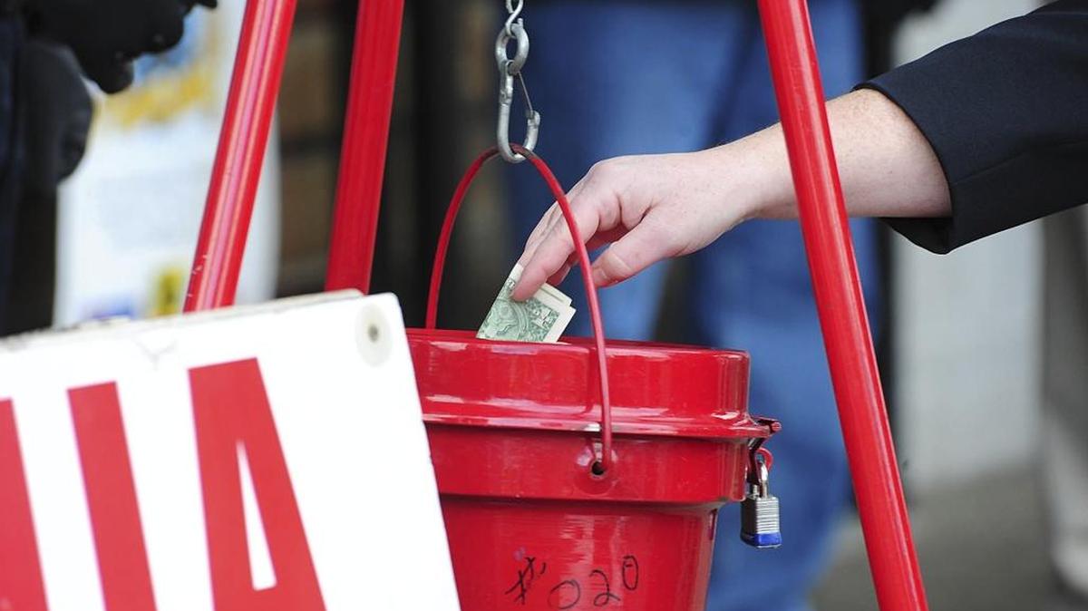 A patron donates money in a Salvation Army red kettle.