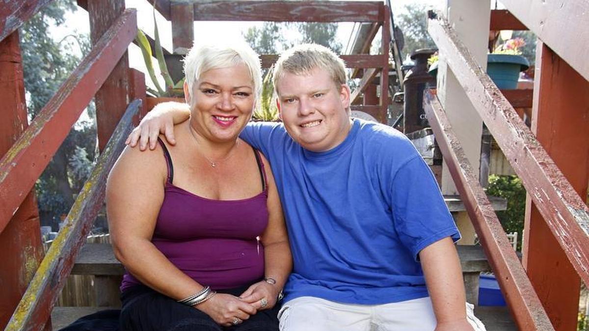 Tyler Jarvis, who has Prader-Willi syndrome, sits with his mom, Michelle Christian, at their Pismo Beach home.