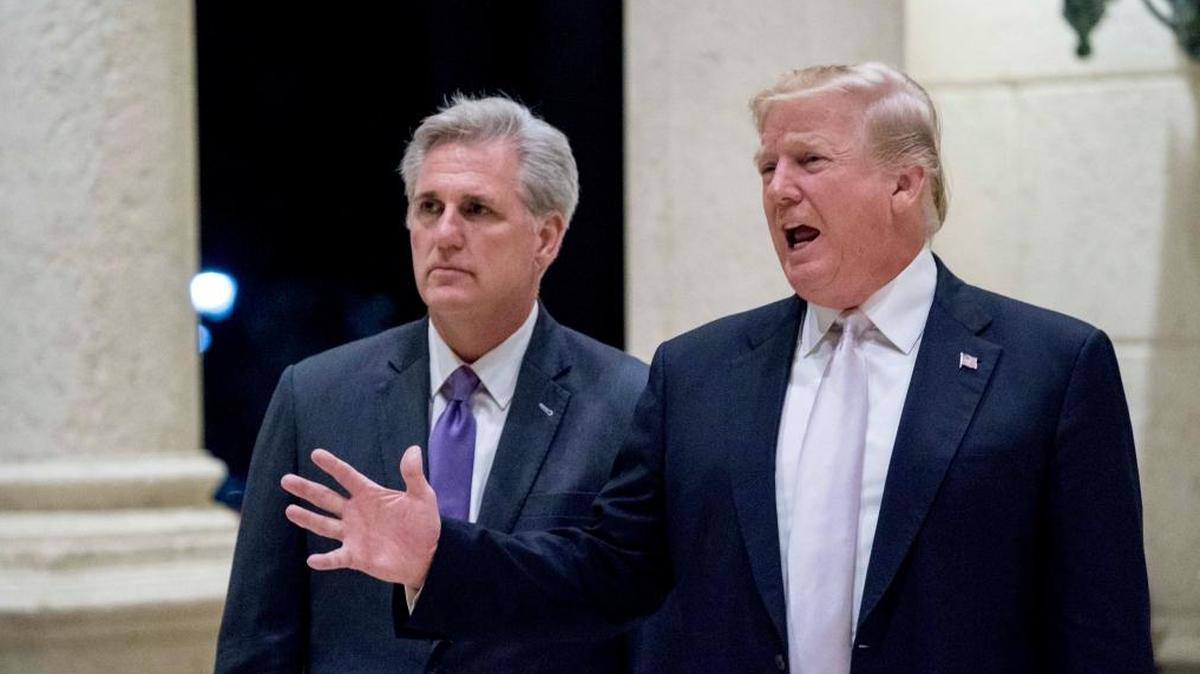 In this Jan. 14, 2018 photo, President Donald Trump, right, accompanied by Rep. Kevin McCarthy, speaks to members of the media as they arrive for a dinner at Trump International Golf Club in West Palm Beach, Florida.