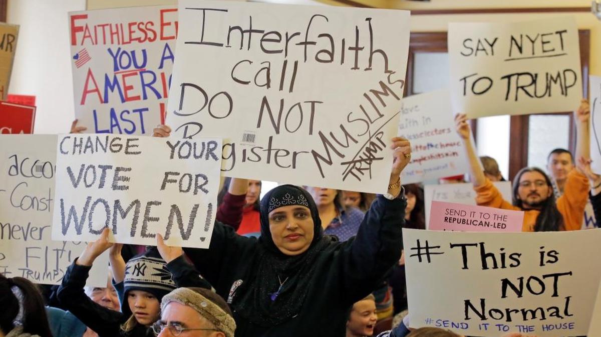 Protesters hold signs as Utah’s six presidential electors prepare to cast their votes for President-elect Donald Trump, Dec. 19, in Salt Lake City. The six electors, who were chosen by Utah GOP delegates earlier in the year, cast their votes in a brief meeting Monday at the state Capitol as protesters filled the room, yelling, “Vote your conscience,” and, “The whole world is watching.”