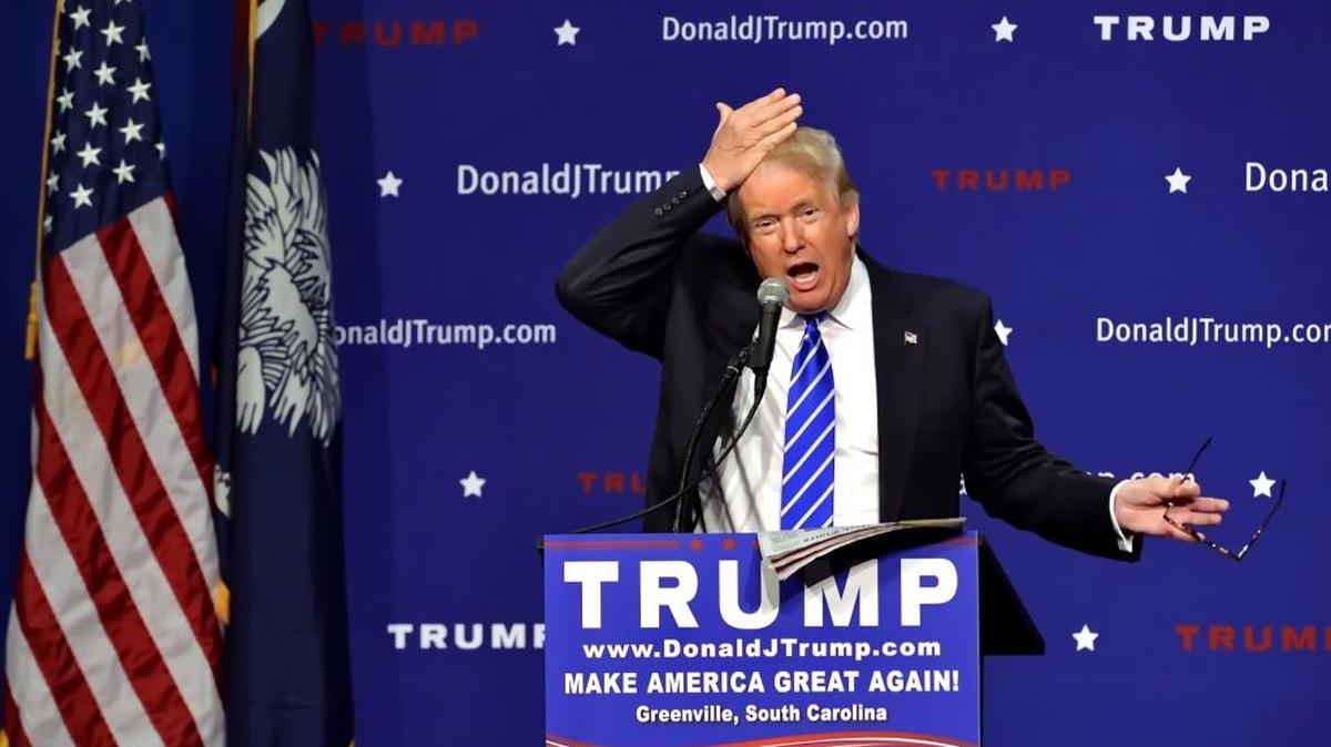Republican presidential candidate Donald Trump pulls his hair back to show that it is not a toupee while speaking during a rally at the TD Convention Center on Thursday, Aug. 27, 2015, in Greenville, S.C.