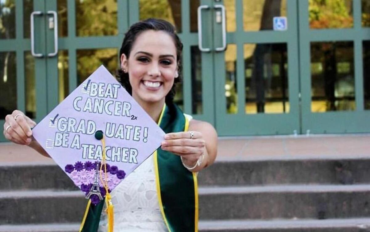 Camille Chabot holds up her mortar board with two of her three goals accomplished: beat cancer and graduate. She's pursuing her third goal to become a teacher.