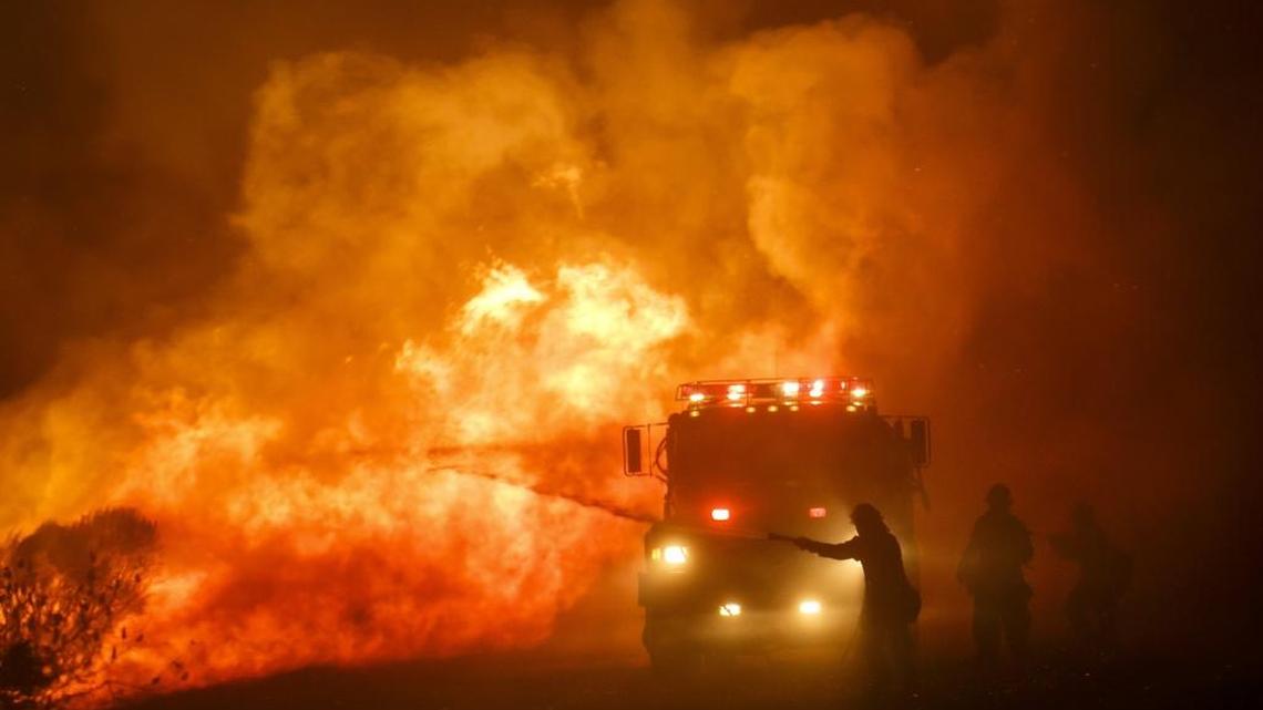 Firefighters combat the front lines of the Sherpa Fire to keep it from moving onto Highway 101, along Calle Real Road in Goleta, on June 16, 2016.