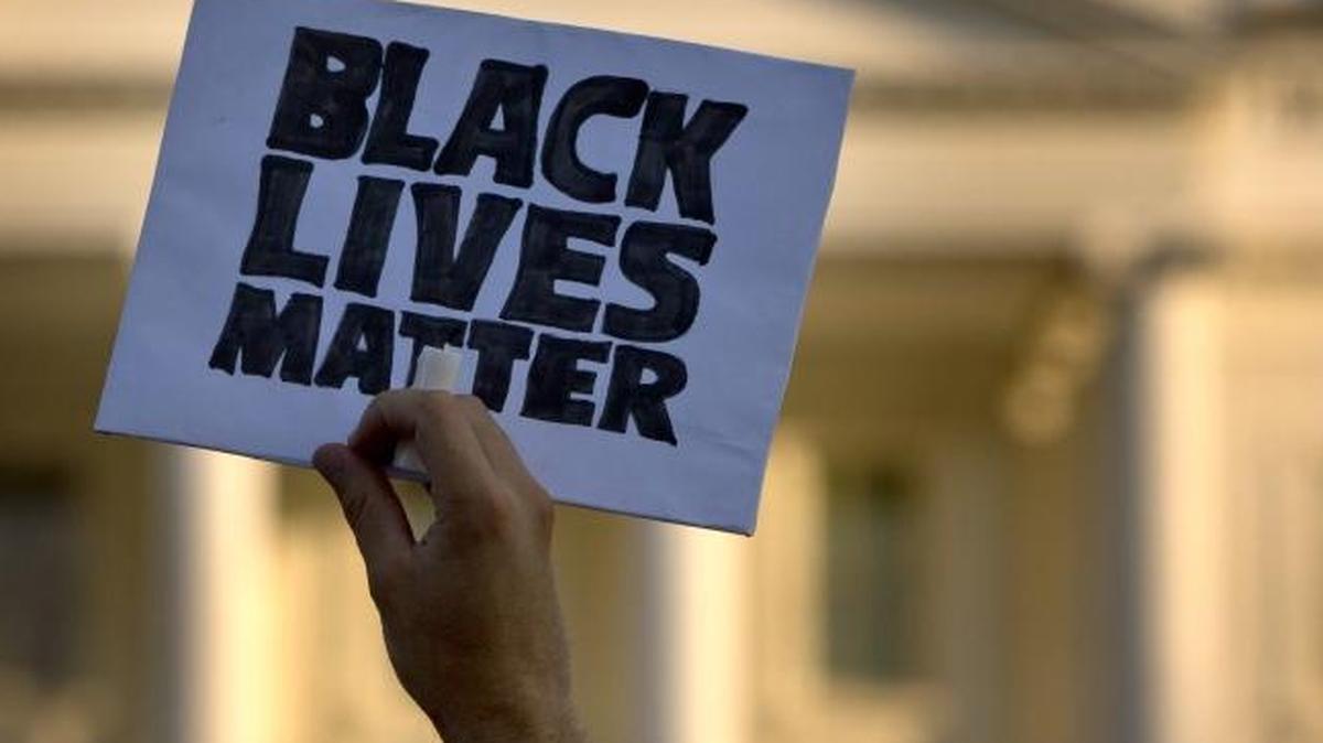 A man holds up a sign saying “Black Lives Matter” during a protest of shootings by police at the White House in Washington.