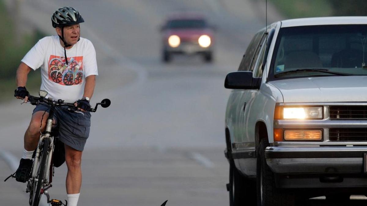 Ronald Wallenfang shares the road with vehicles while passing through Menomonee Falls, Wisconsin.