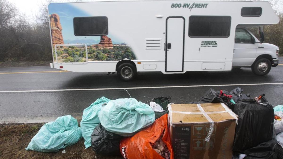 Trash pulled out from the camp lines Highway 1 as vacationers drive by in RVs in January. A large group of homeless residents had set up camp along Highway 1 and the railroad tracks in Grover Beach, before being removed so that the Grover Beach Amtrak station could be renovated.
