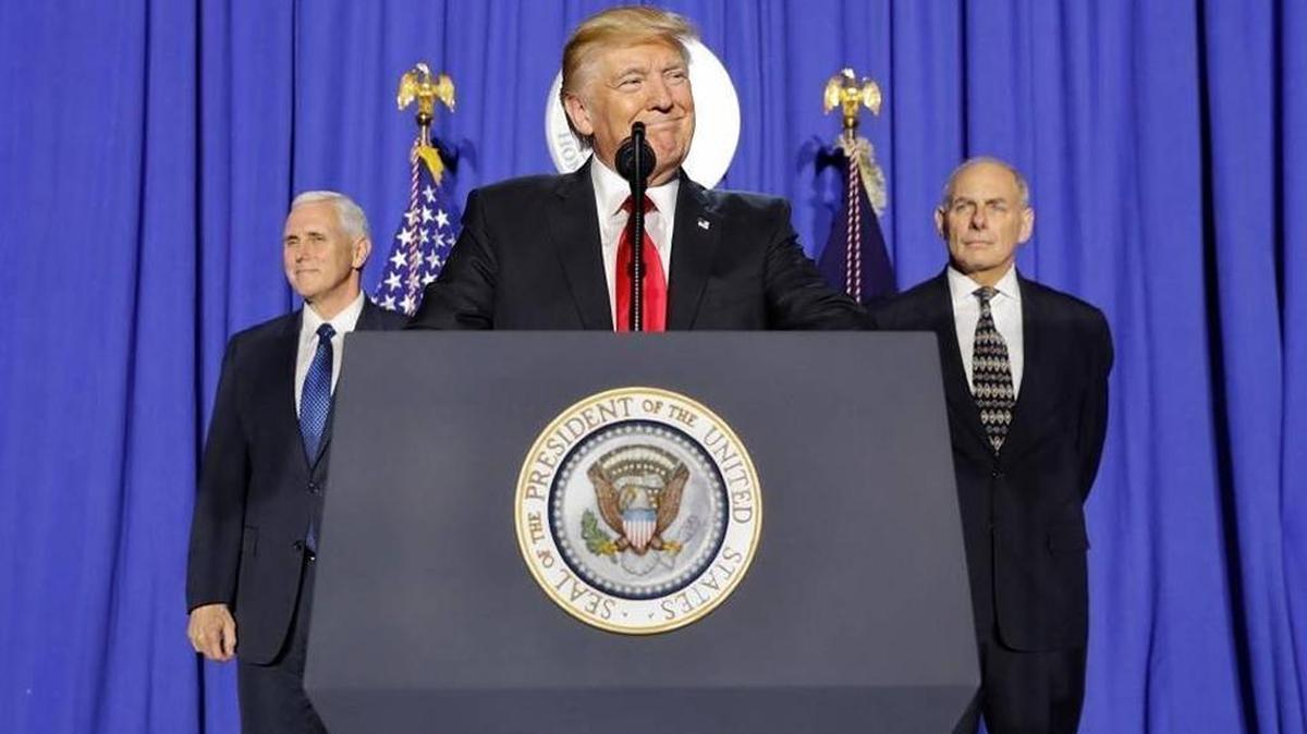 President Donald Trump, accompanied by Vice President Mike Pence, left, and Homeland Security Secretary John F. Kelly, pauses while speaking at the Homeland Security Department in Washington.
