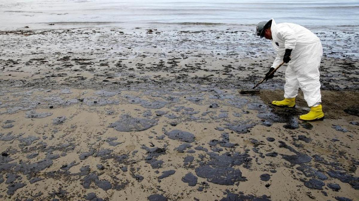 In this May 21, 2015 file photo, a worker removes oil from the sand at Refugio State Beach in the Santa Barbara Channel, north of Goleta.