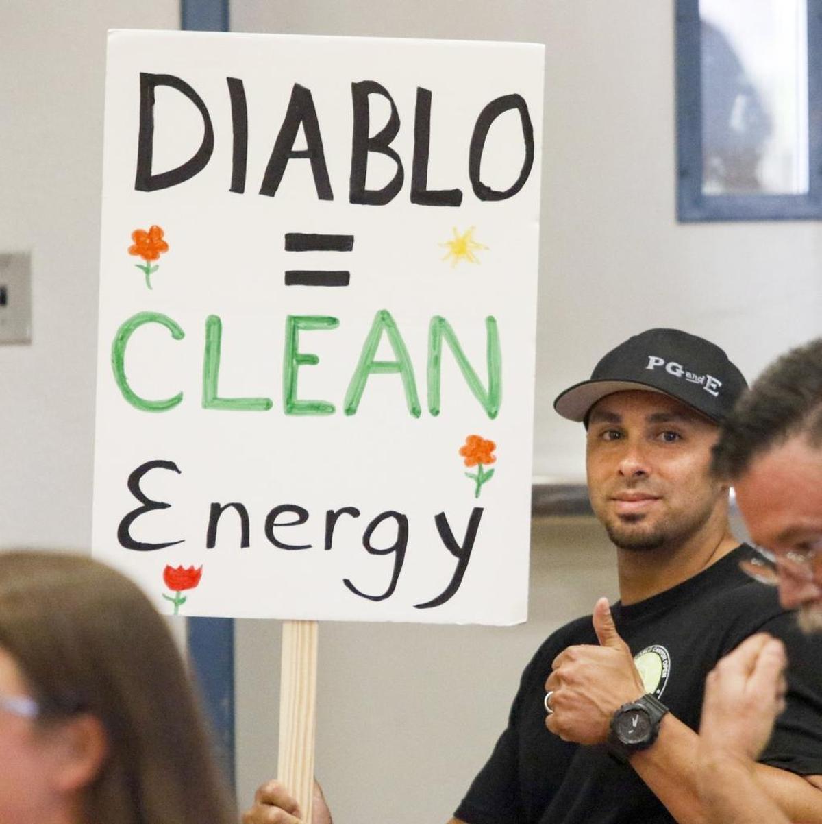Albert Contreras holds a placard at State Lands Commission Hearing in Morro Bay in June 2016.