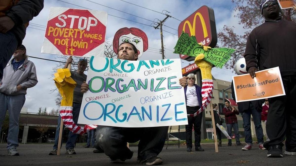 James "Faygo" Clark, of Sacramento with Occupy Sacramento holds a sign in support of unionizing fast-food workers during a Dec. 14, 2014, demonstration, part of a national campaign to seek a $15 per hour minimum age and unionization.