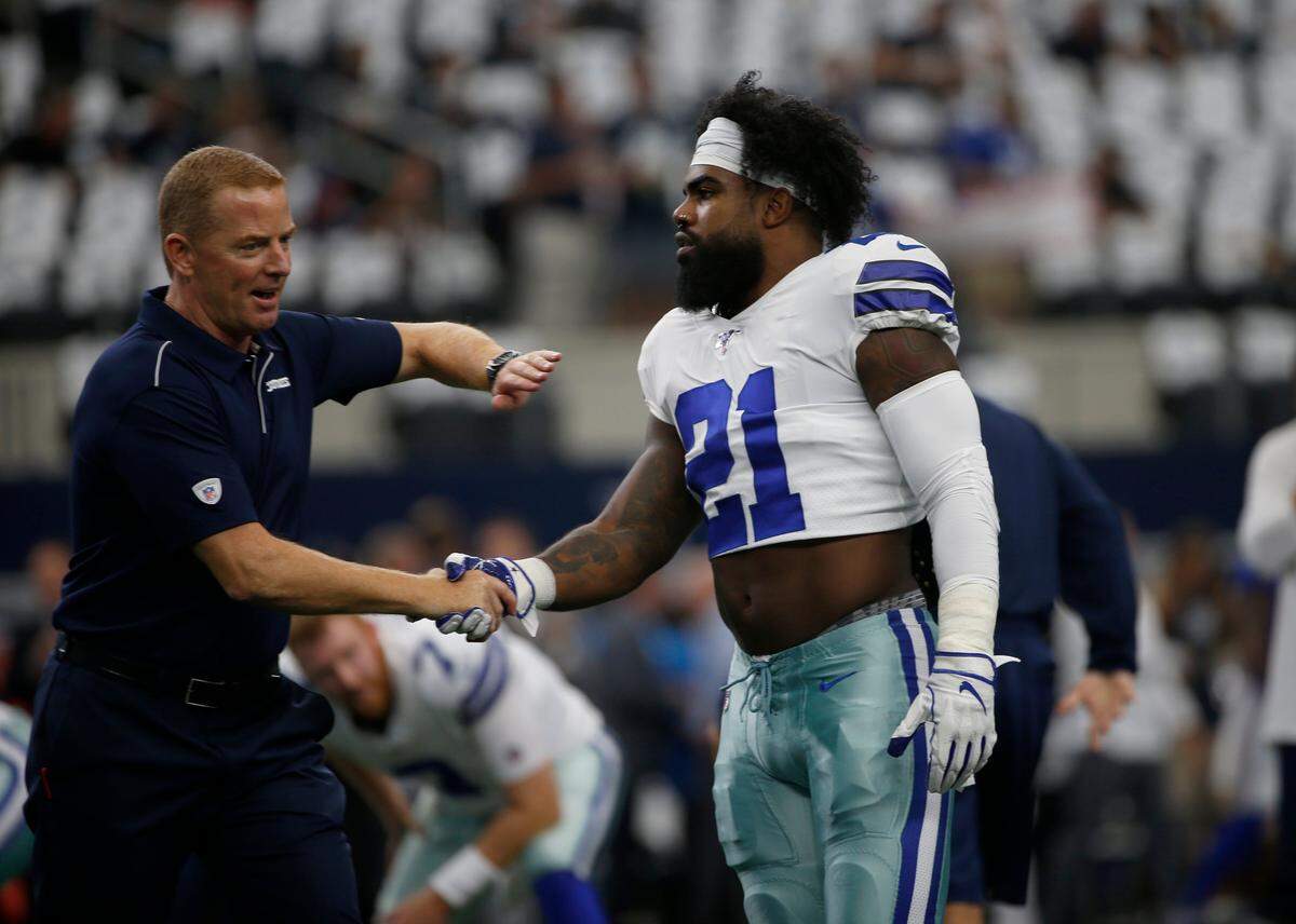 Dallas Cowboys head coach Jason Garrett and running back Ezekiel Elliott (21) greet each other before a NFL football game against the New York Giants in Arlington, Texas, Sunday, Sept. 8, 2019.