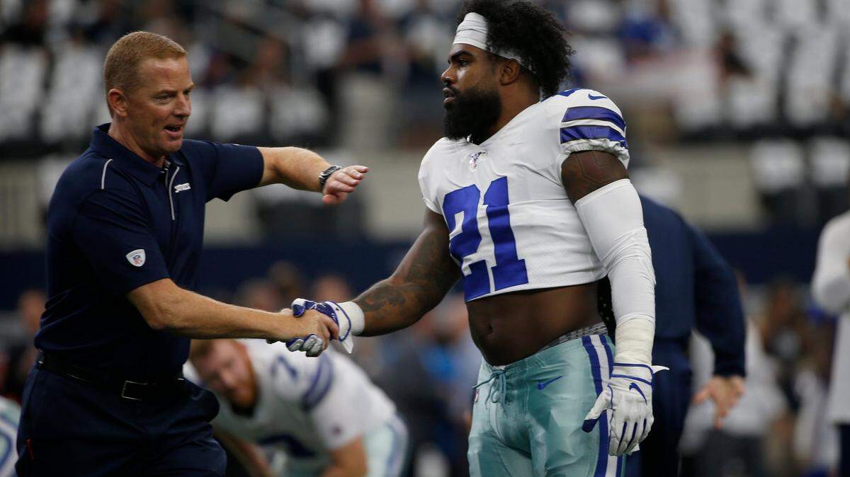 Dallas Cowboys head coach Jason Garrett and running back Ezekiel Elliott (21) greet each other before a NFL football game against the New York Giants in Arlington, Texas, Sunday, Sept. 8, 2019.