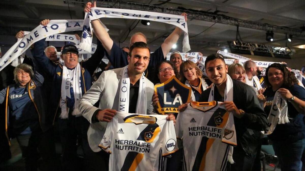 Former Cal Poly men’s soccer star Justin Dhillon (left) and Hugo Arellano (right) celebrate with L.A. Galaxy fans after they were introduced following their signings.