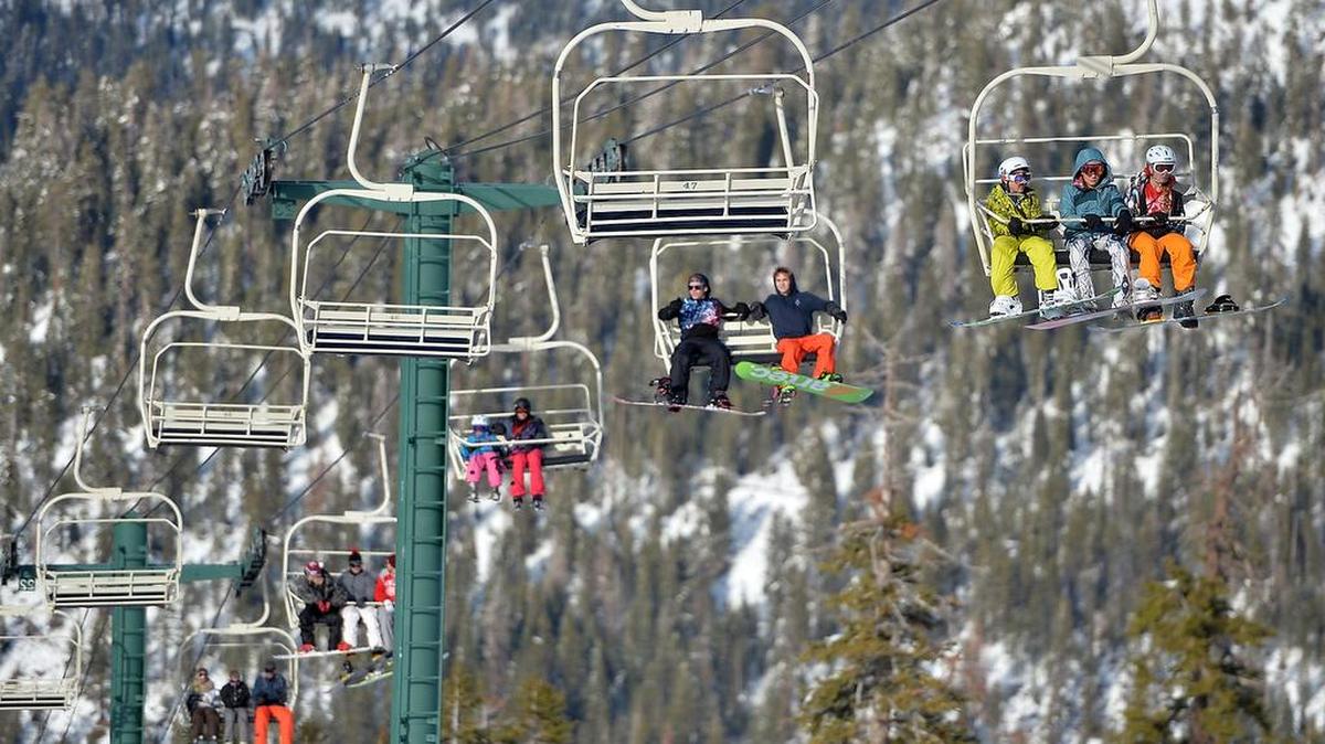 In a December 2015 file photo, snowboarders and skiers ride a lift to the summit China Peak ski area near Huntington Lake.
